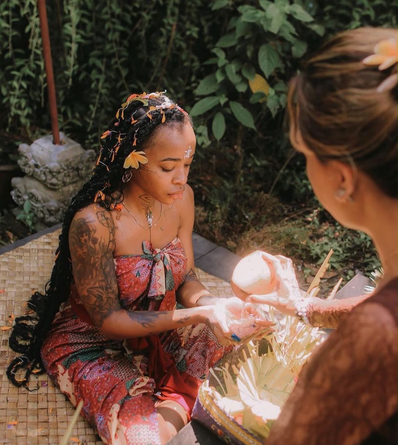 Sharon performing a grounding water blessing ritual outdoors, in ceremonial dress